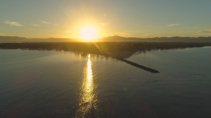 AERIAL: Golden sun rising above exotic Fiji island on early morning in summer