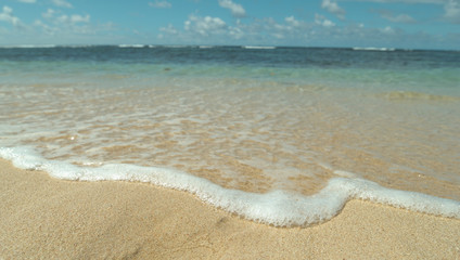 CLOSE UP: Turquoise waves roll in on the peaceful shore on tropical island.