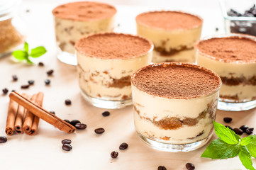 Homemade tiramisu, traditional Italian dessert in glass on wooden table