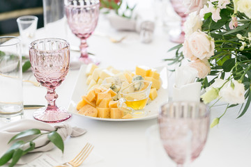 Cheese platter. Plate with food on the table, snacks at the banquet, wedding banquet, table setting, dinner food, gala dinner.