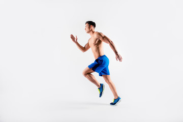 Fototapeta na wymiar Portrait of concentrated confident muscular full of strength sportsman wearing shorts and sneakers, he is running a marathon, isolated on white background