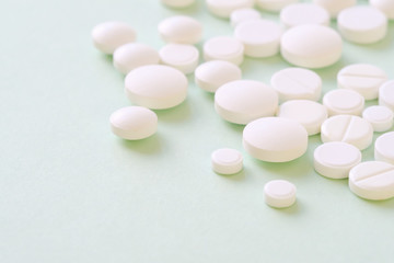 Fototapeta na wymiar Pharmaceutical medicine pills, tablets and capsules over green