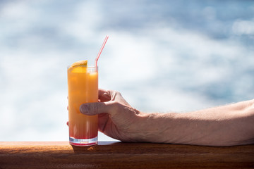 Senior caucasian adult man with tequila sunrise
