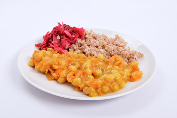 Stewed carrots with chickpeas and buckwheat on a white