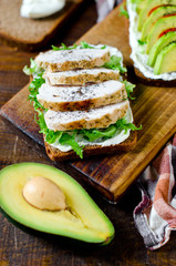 Various healthy toasted sandwiches: avocados, tomatoes, lettuce, chicken breast and curd cheese. healthy snacks