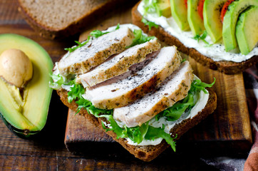 Various healthy toasted sandwiches: avocados, tomatoes, lettuce, chicken breast and curd cheese. healthy snacks