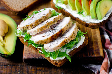 Various healthy toasted sandwiches: avocados, tomatoes, lettuce, chicken breast and curd cheese. healthy snacks