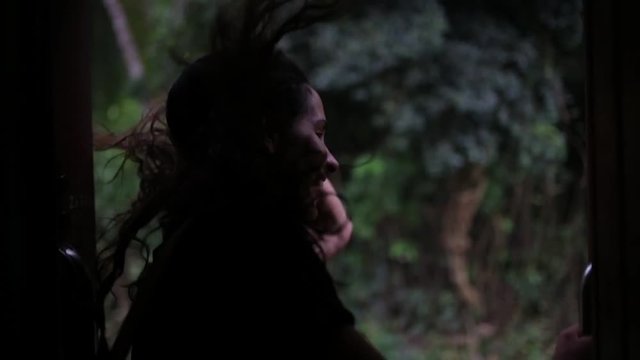 the girl is traveling by train in tropical forest.