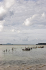 Fototapeta na wymiar Fishing boats moored at Chalong Bay in Phuket, Thailand on a calm sea with scattered cloud