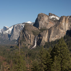 the yosemite waterfall in spring with snow on the summits