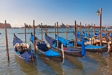 Six boats gondolas at the pier in the Grand Canal, Venice, Italy