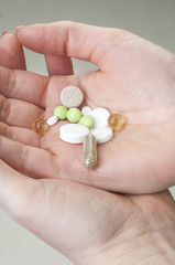 Multicolor pills in your palm, medications in woman's hand