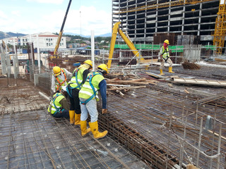 Construction workers fabricating steel reinforcement bar at the construction site. The reinforcement bar was tied together using tiny wire.    