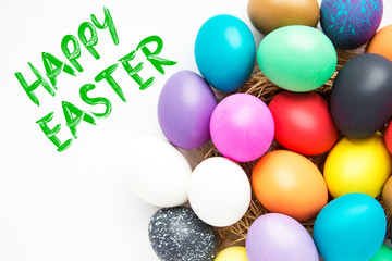 Multi-colored Easter eggs in nest on wooden background, selective focus image. Happy Easter card 