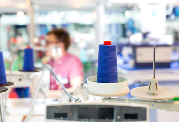 Spools of blue threads on sewing machine, factory