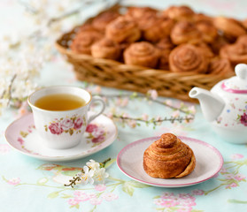 Cinnamon buns with tea and spring flowes