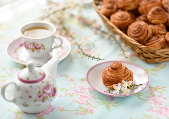 Obraz na płótnie Canvas Cinnamon buns with tea and spring flowes