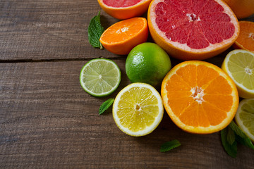 Fototapeta na wymiar mixed citrus fruits on dark wooden background