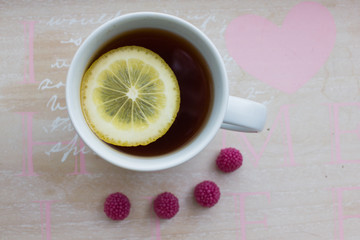 Cup of tea with lemon and raspberry sweets
