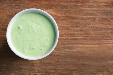 Tasty creamy sauce for fish taco in bowl on wooden table
