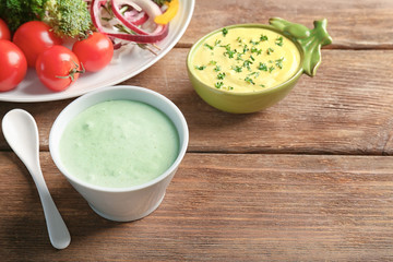 Tasty creamy sauce for fish taco in bowl on wooden table