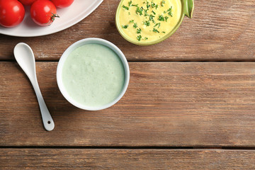 Tasty creamy sauce for fish taco in bowl on wooden table