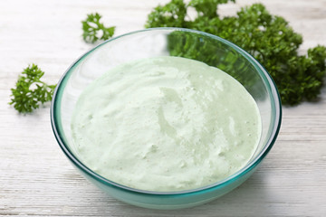 Tasty creamy sauce for fish taco in bowl on wooden table