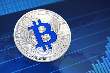 Silver bitcoin on screen with chart. Finance trading