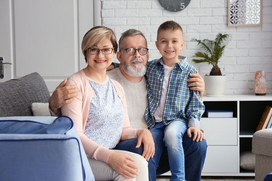 Happy senior couple with little grandson at home