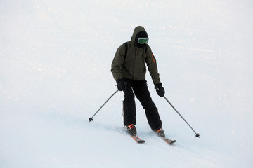 Fototapeta na wymiar Man skiing at snowy resort. Winter vacation