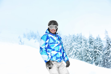 Fototapeta na wymiar Man on ski piste at snowy resort. Winter vacation