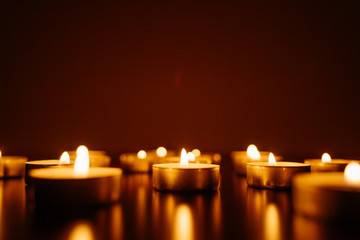 Kemerovo, Russia, fire in the mall, burning candles. Shallow depth of field. Many candles burning at night. Candles background. Many candle flames glowing on dark background. Close-up. Free space.