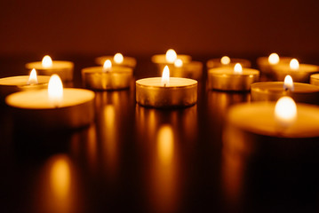 Kemerovo, Russia, fire in the mall, burning candles. Shallow depth of field. Many candles burning at night. Candles background. Many candle flames glowing on dark background. Close-up. Free space.