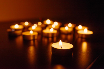 Kemerovo, Russia, fire in the mall, burning candles. Shallow depth of field. Many candles burning at night. Candles background. Many candle flames glowing on dark background. Close-up. Free space.