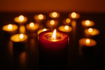 Kemerovo, Russia, fire in the mall, burning candles. Shallow depth of field. Many candles burning at night. Candles background. Many candle flames glowing on dark background. Close-up. Free space.