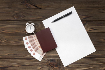 Passport, money, clock, sheet of paper on a wooden background. credit for 15 minutes