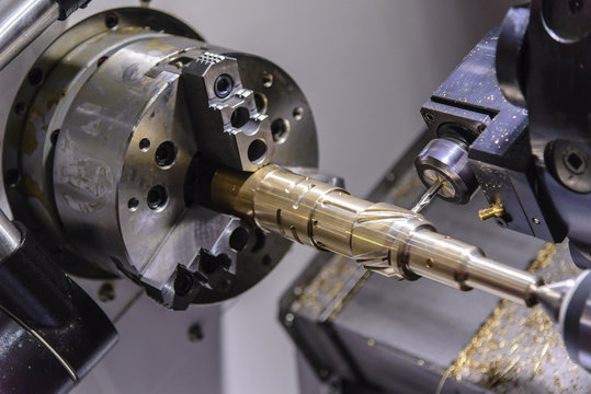 The CNC lathe machine cutting the brass shaft  part  by milling spindle.