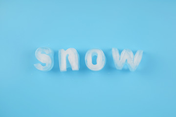 Fototapeta premium Snow ice alphabet made of ice cubes on blue background.