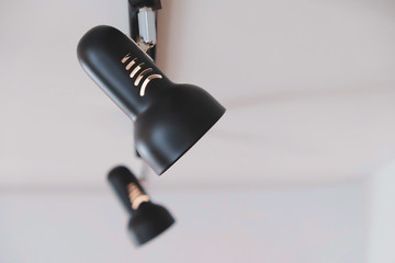 Close up black LED downlight lamp installation on black ceiling.