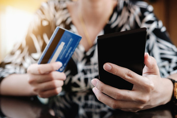 Online payment,Young Woman's using smart phone and holding credit card for online shopping.