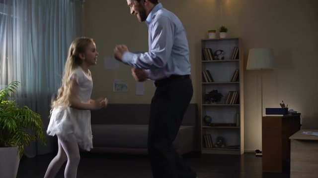 Little daughter and father enjoying dance at home, having fun together, party