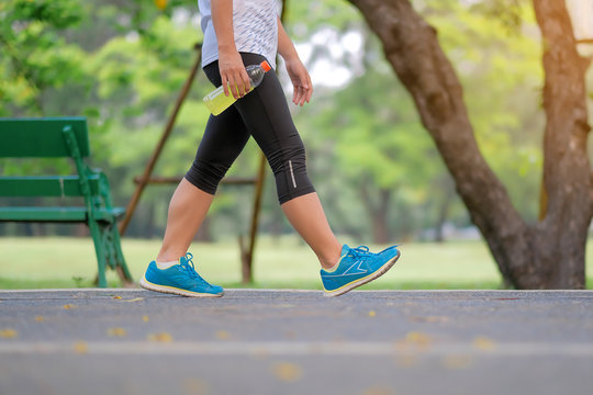 Young Fitness Woman Legs Walking In The Park Outdoor, Female Runner Running On The Road Outside, Asian Athlete Jogging And Exercise On Footpath In Sunlight Morning. Sport,healthy And Wellness Concepts