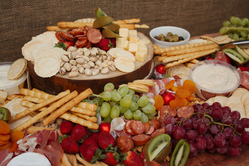 A Delicious Food Platter of Fruit, Nuts, Chesse, Dips, Deli Meats and crackers.