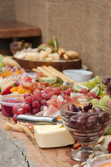 A Delicious Food Platter of Fruit, Nuts, Chesse, Dips, Deli Meats and crackers.