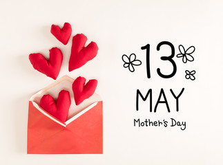 Mother's Day message with red heart cushions coming out of an envelope