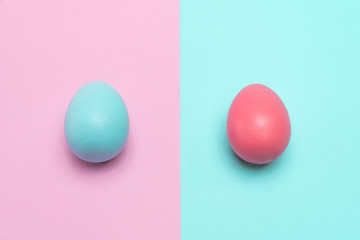 Two easter eggs stay static on table.