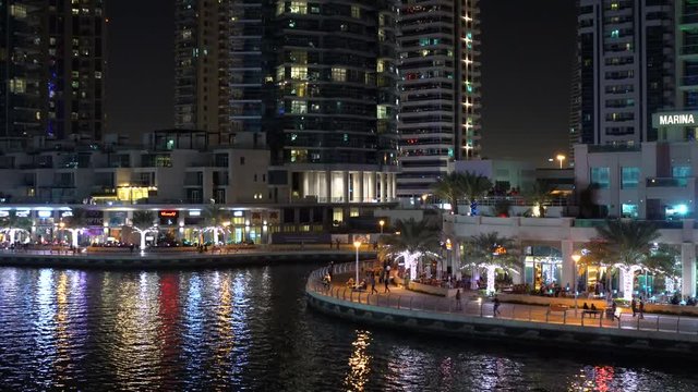 People walking on Dubai Marina's waterfront at night