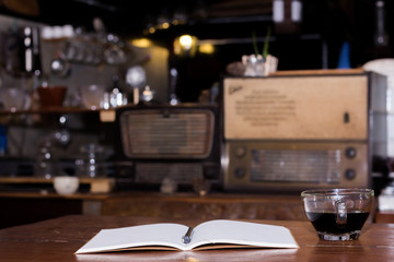 Fototapeta na wymiar Black coffee cup and wooden desk diary