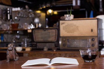 Fototapeta na wymiar Black coffee cup and wooden desk diary