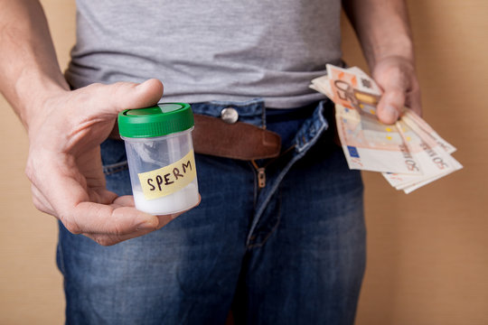 Passing a sample of sperm into a sperm bank for money. How to earn having received pleasure. Guy holding a jar of sperm and money euros